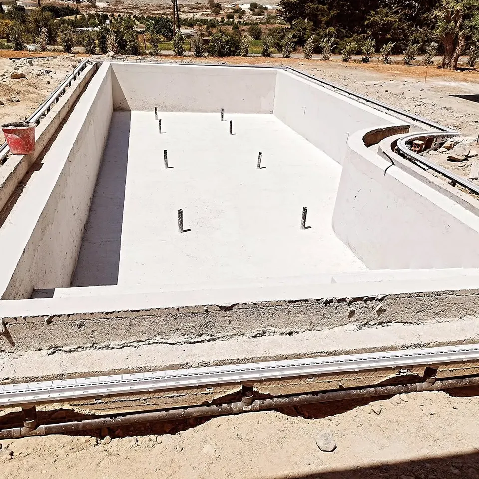A freshly rendered pool shell on site, before the tiles go in